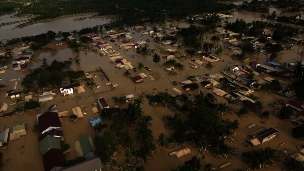 Aerial view of a flooded town — houses and streets under muddy water after a disaster